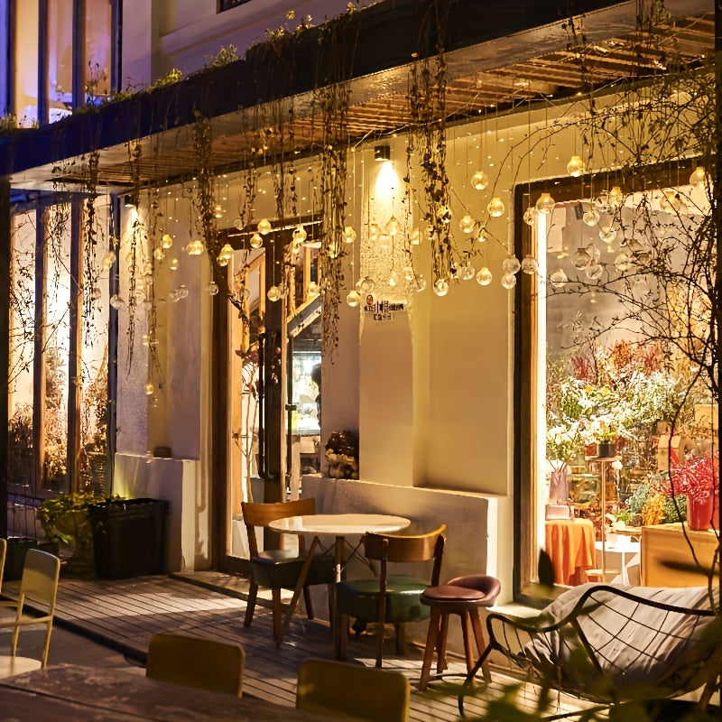 Färgglada ljus med hängande globprydnader Carvallo