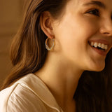 Eleganta gyllene vridna creoler örhängen med nätmönster Carvallo