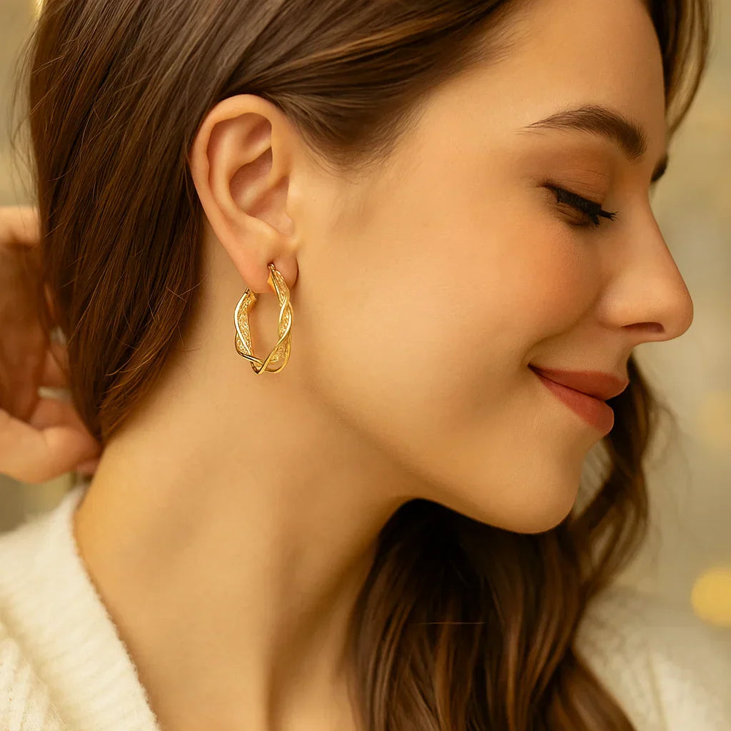 Eleganta gyllene vridna creoler örhängen med nätmönster Carvallo