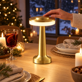Sladdlös uppladdningsbar bordslampa i guld tänds med touch på ett dukat julbord med glögg och levande ljus